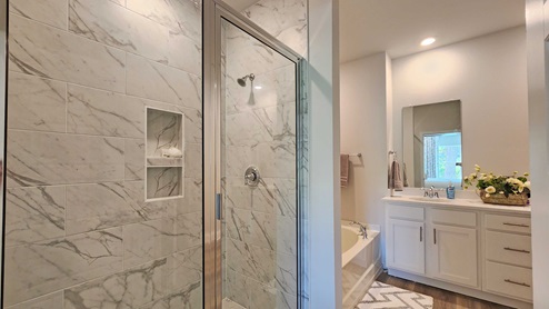 The Dover primary bathroom with standing shower, garden tub and dual sink vanity.