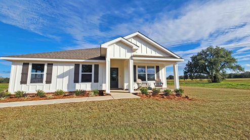 Magnolia Farms white model home with tree.