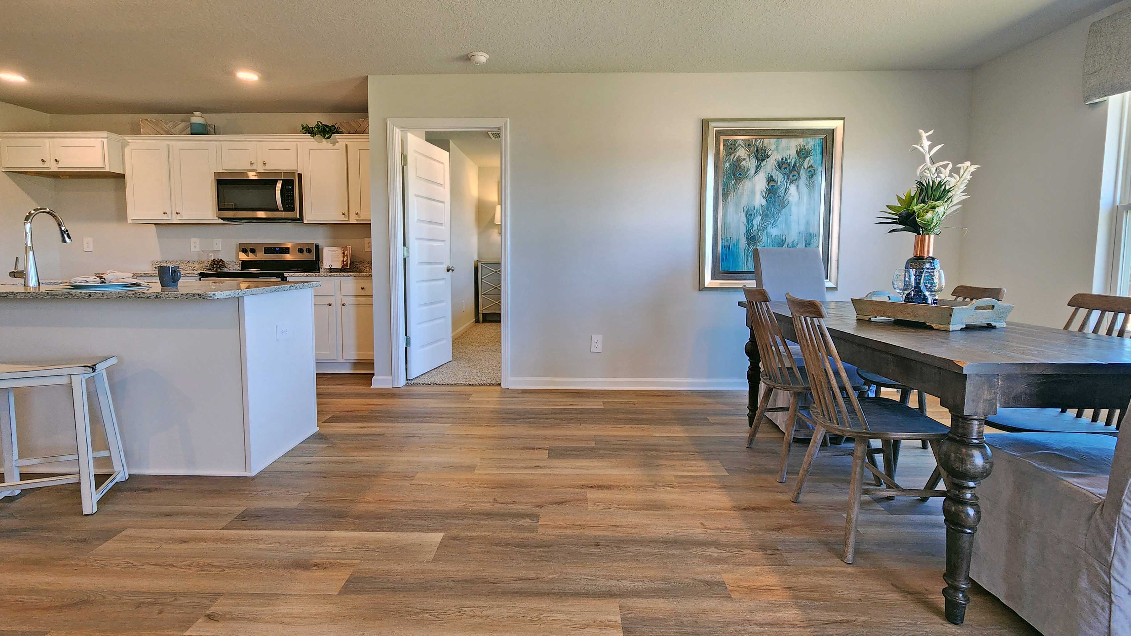 White shaker-style cabinetry with island and granite countertops.