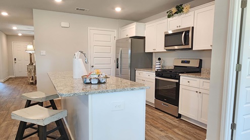 Aria kitchen with white shaker-style cabinetry and island.