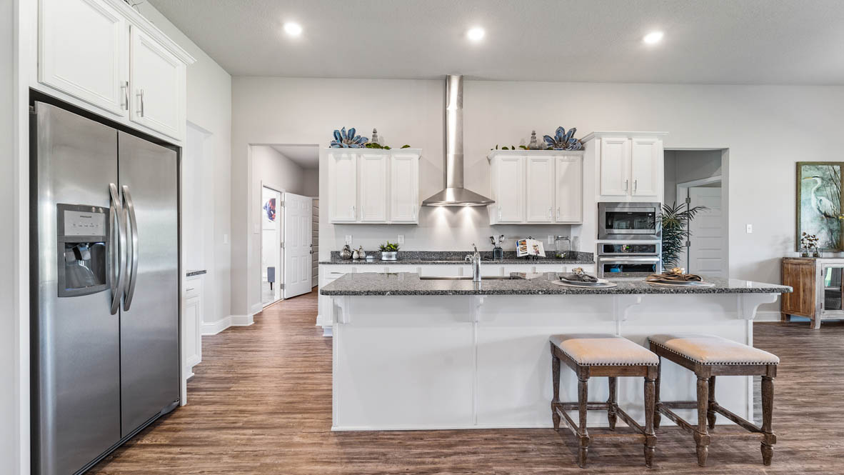 Modern white kitchen with luxury finishes and recessed lighting in Epley Station.