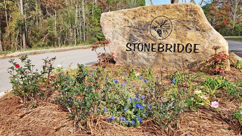 Community entrance monument for Stonebridge. Large rock with flowers.