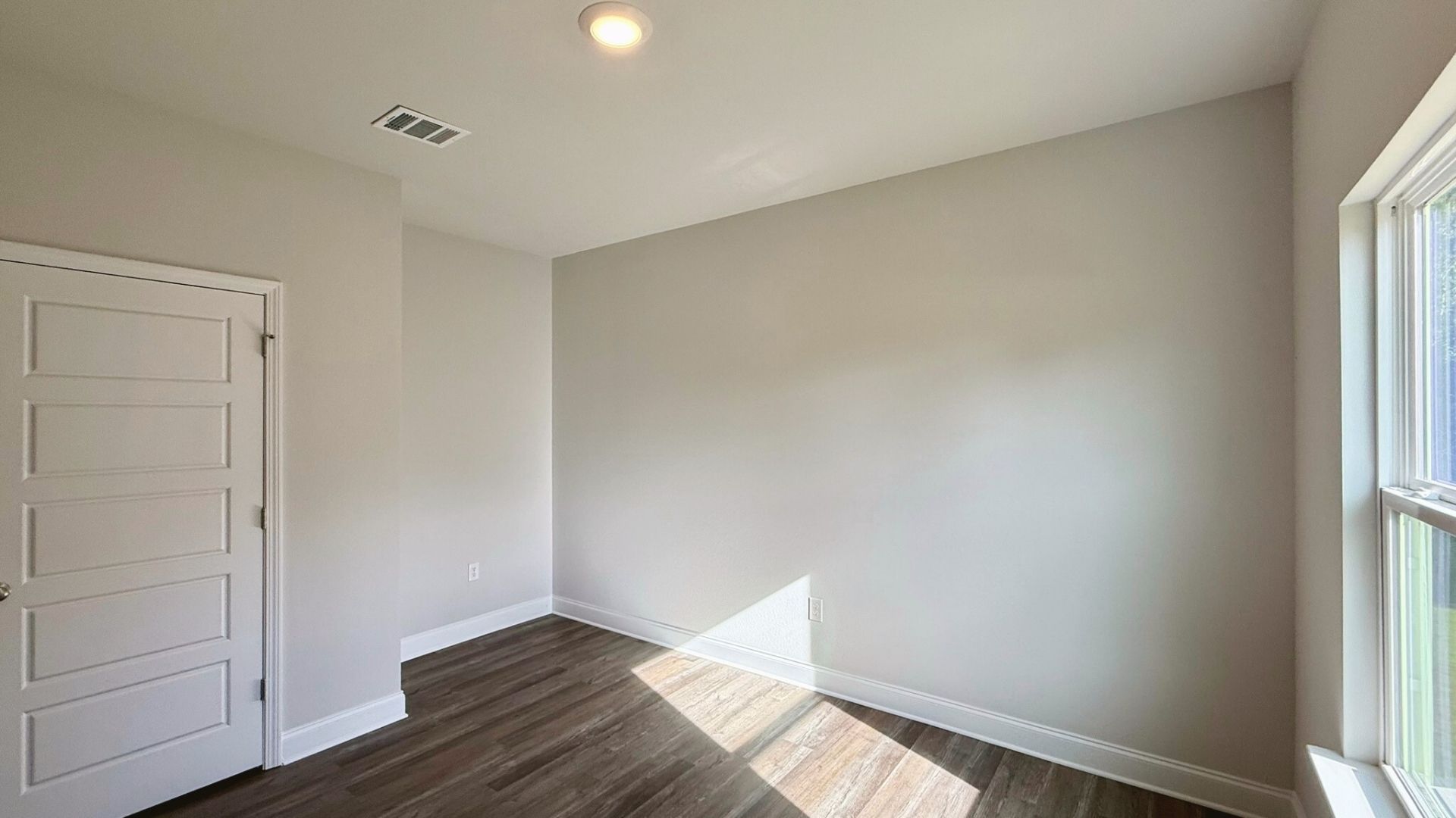 Bedroom with brown flooring.