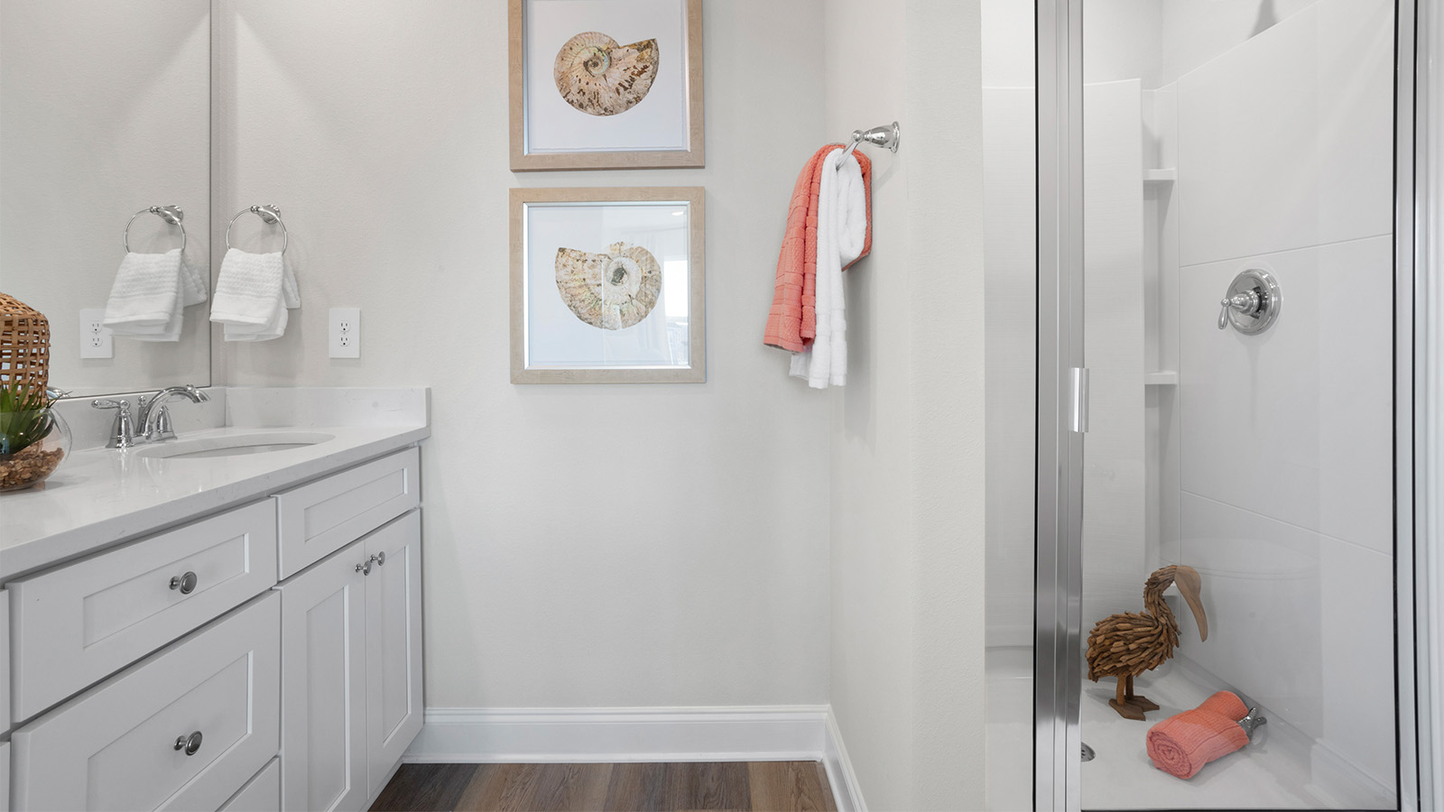 Spacious primary bathroom with walk in shower and luxury vinyl plank flooring on the gulf coast.