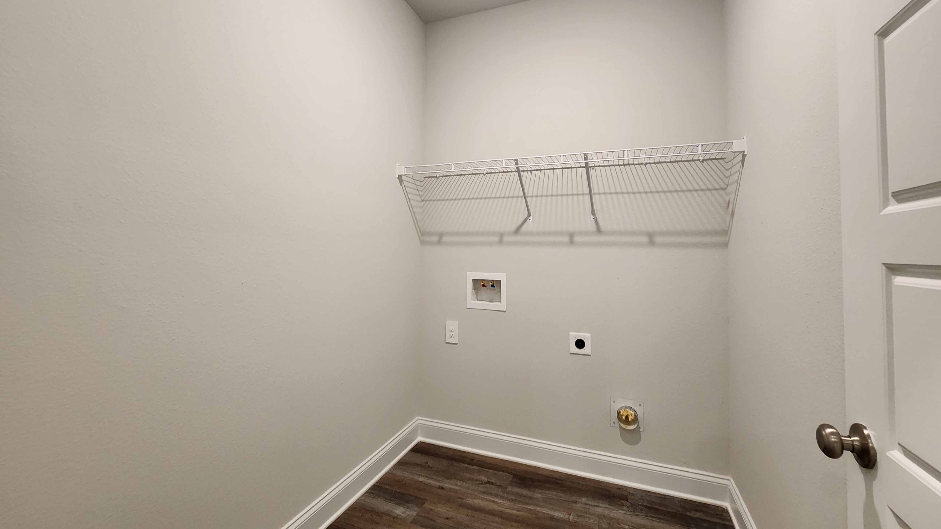 Laundry room with neutral tones and shelving