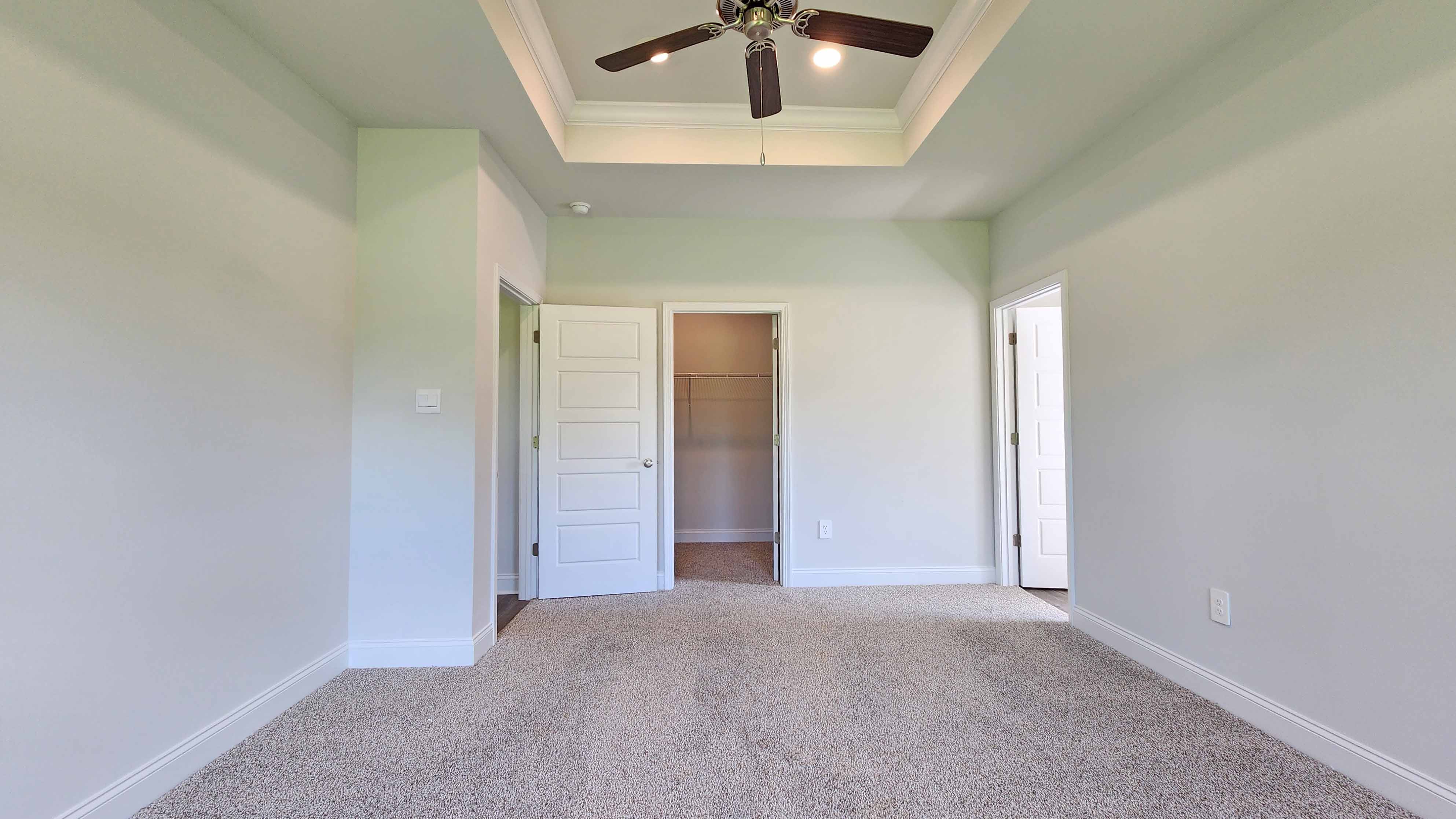 The Holly by DR Horton offers a stylish primary bedroom with a ceiling fan and ample natural light