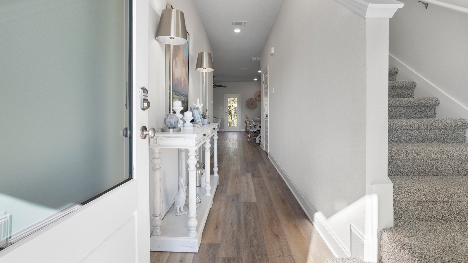 This bright stairwell with luxury vinyl plank flooring is featured in a home at Harper Grove.