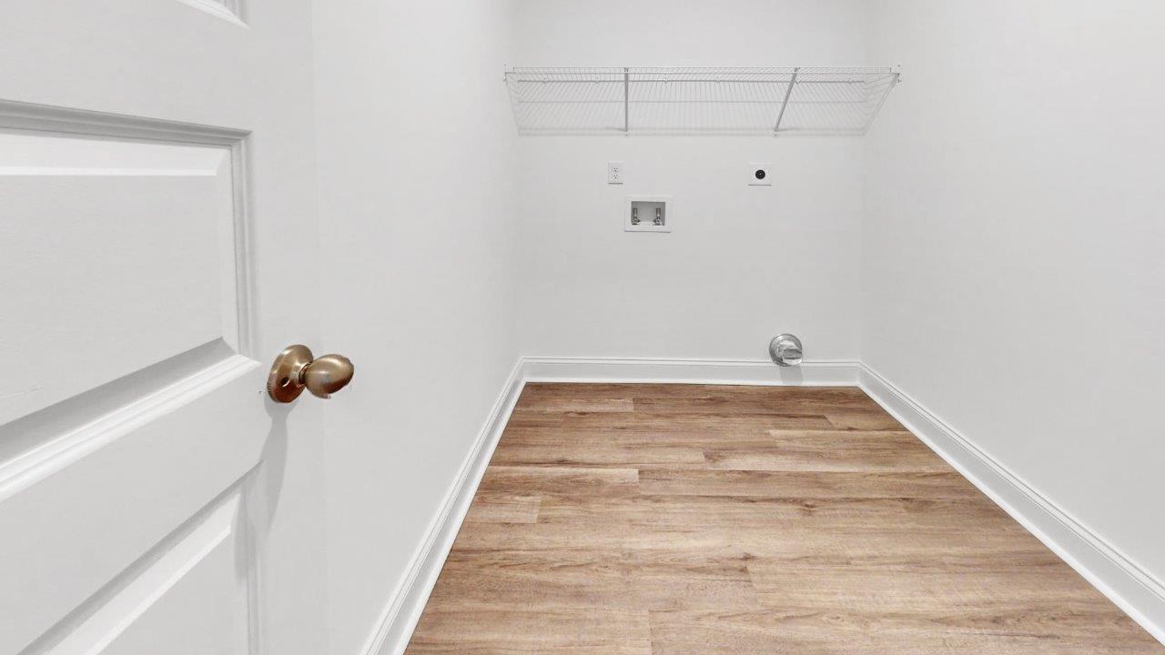 Spacious laundry area with durable flooring and storage options