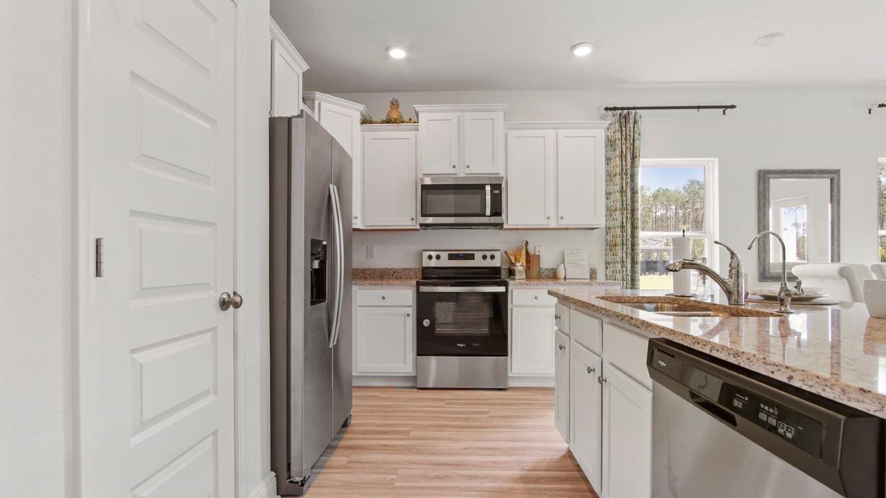 Well equipped kitchen with stainless appliances and polished quartz countertops.