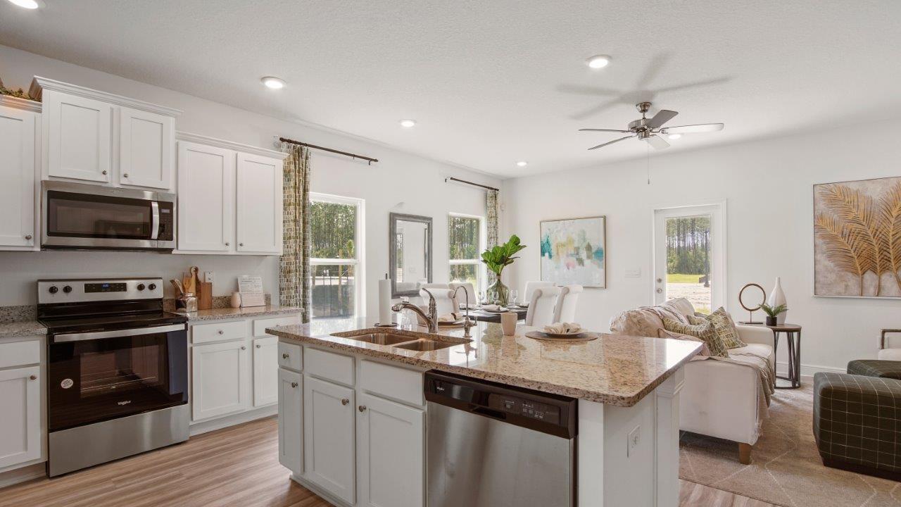 Well equipped kitchen with stainless appliances and polished quartz countertops.
