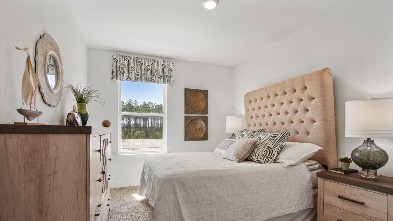 Bright guest room featuring plush carpet and a well sized closet.