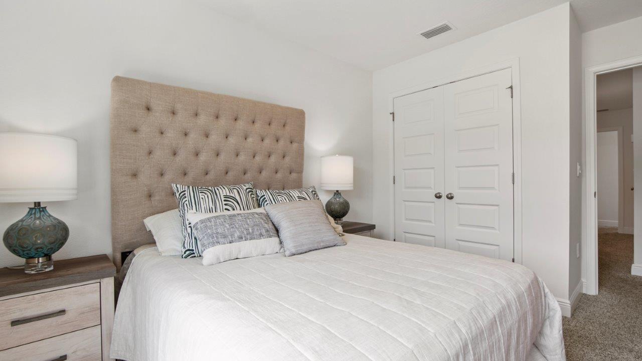 Bright guest room featuring plush carpet and a well sized closet.