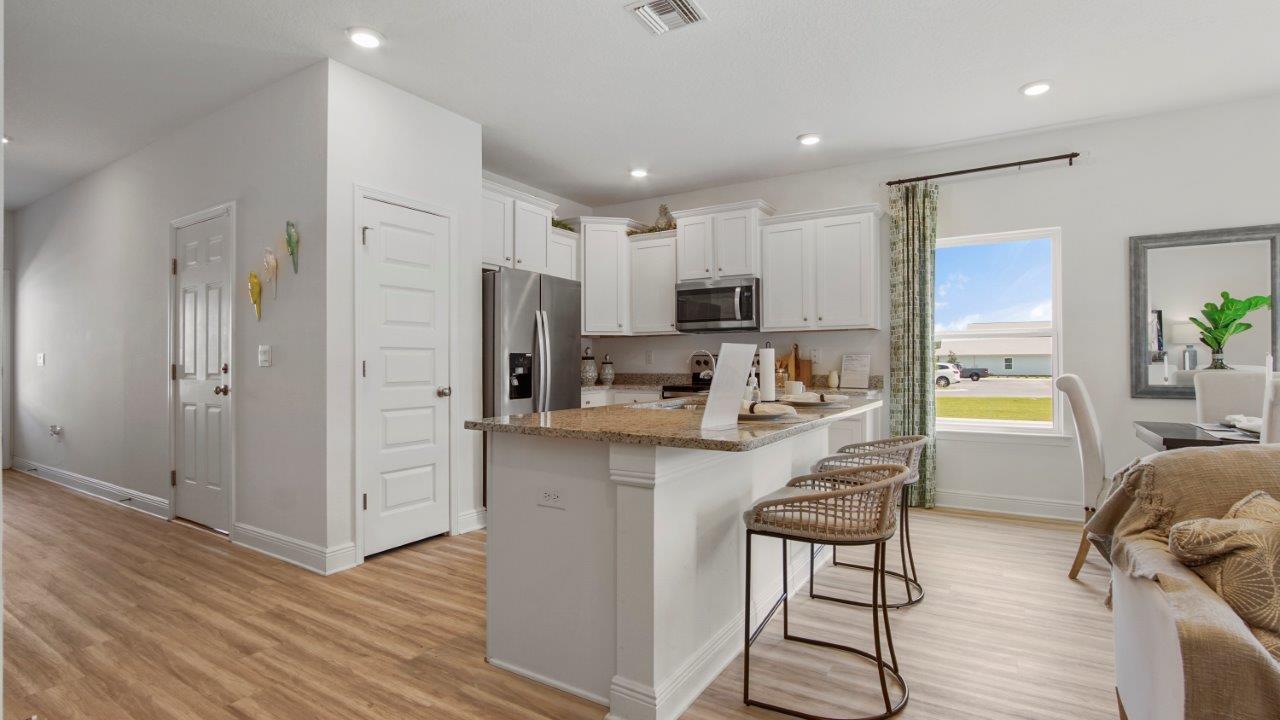 Functional kitchen featuring quartz counters, LVP flooring, and modern appliances.