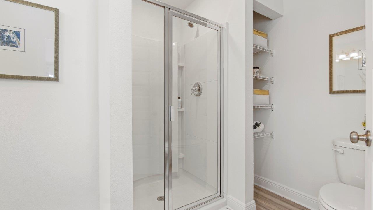 Bright primary bathroom with quartz countertops, and a standalone shower, and a walk in closet.