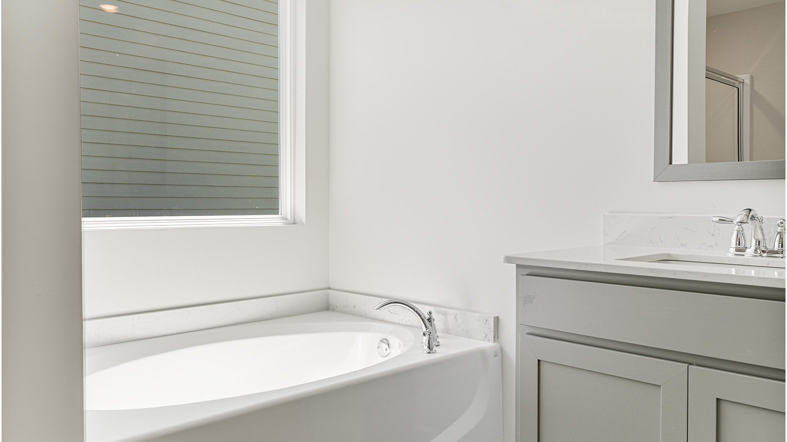 luxury vinyl plan flooring in bathrooms with quartz countertops with double sink vanity and separate garden tub and shower