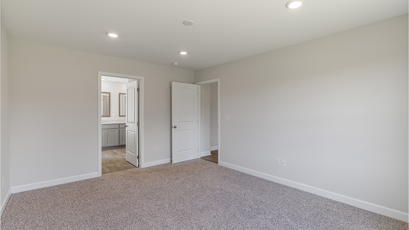 Relaxing primary retreat featuring plush carpet and generous room for furniture.
