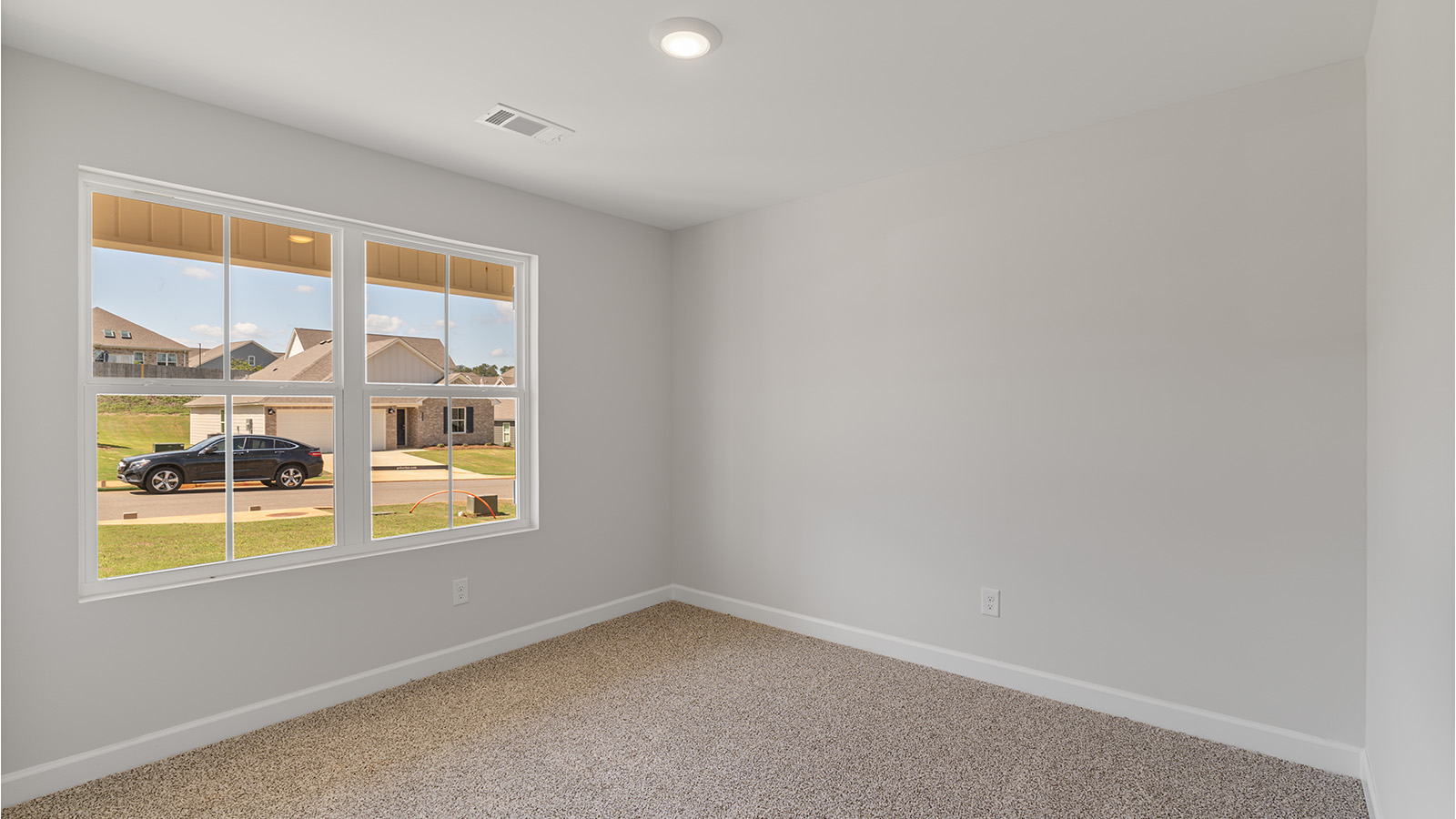 Comfortable guest bedroom with soft carpet and a spacious closet.