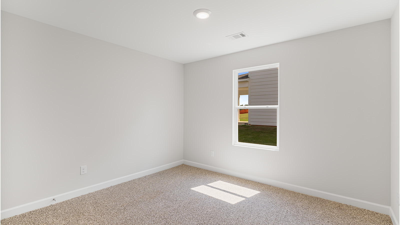 Comfortable guest bedroom with soft carpet and a spacious closet.
