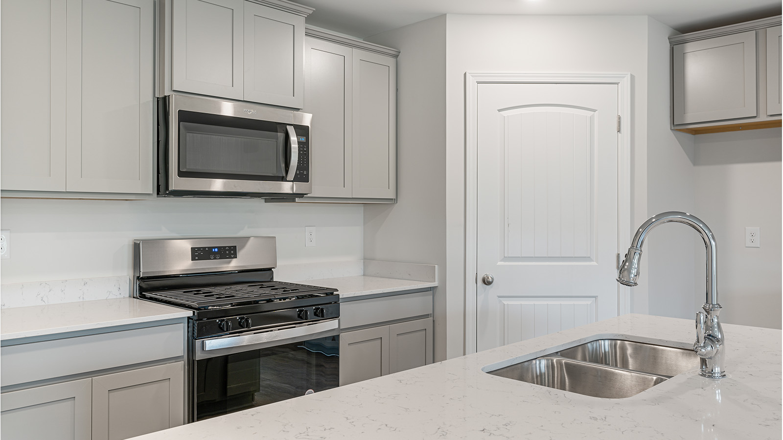 Functional kitchen featuring quartz counters, LVP flooring, and modern appliances.