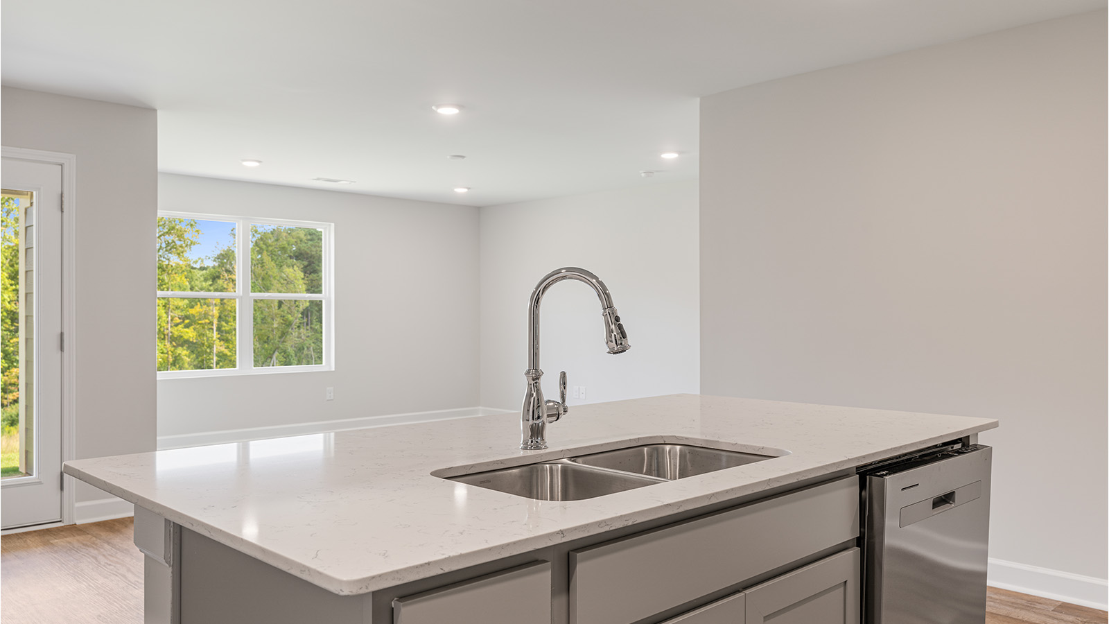 Functional kitchen featuring quartz counters, LVP flooring, and modern appliances.