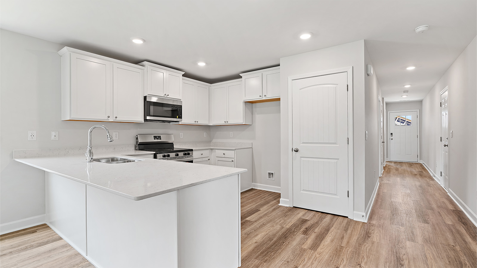 luxury vinyl plank flooring in kitchen with stainless steel appliances and Quartz countertops with soft close cabinets