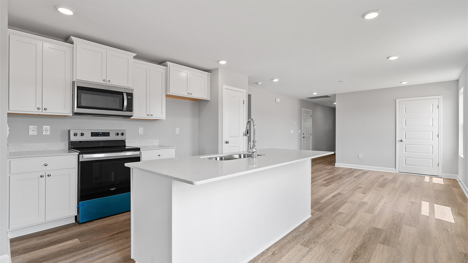 luxury vinyl plank flooring in kitchen with stainless steel appliances and Quartz countertops with soft close cabinets