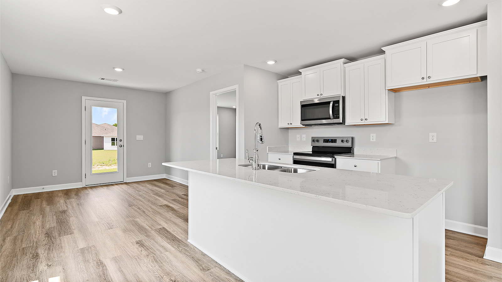 luxury vinyl plank flooring in kitchen with stainless steel appliances and Quartz countertops with soft close cabinets