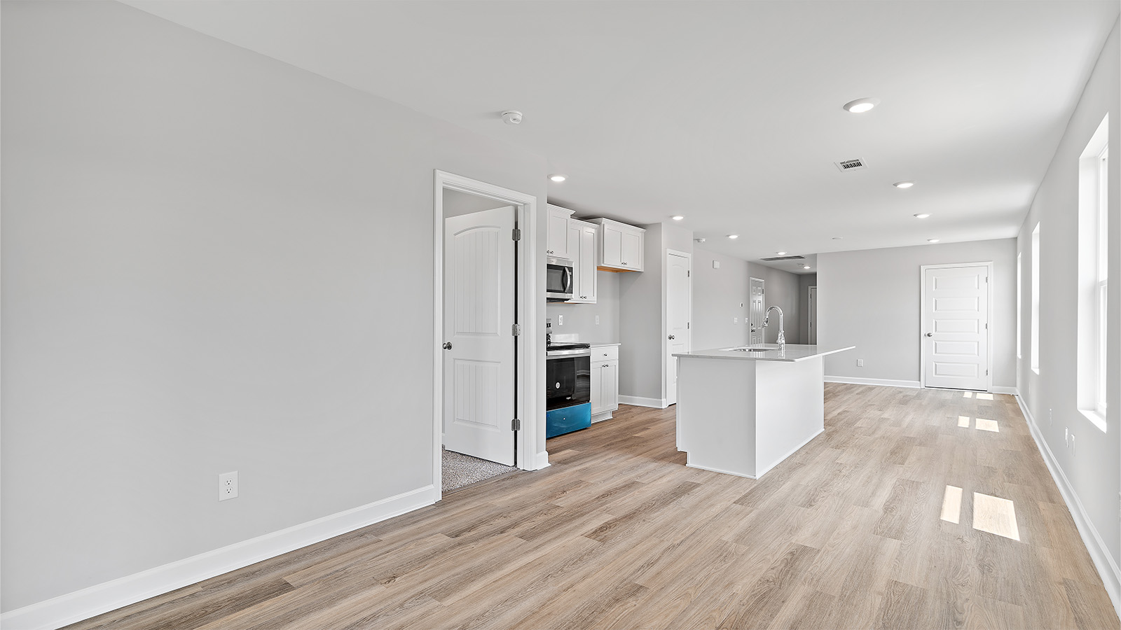 luxury vinyl plank flooring in kitchen with stainless steel appliances and Quartz countertops with soft close cabinets
