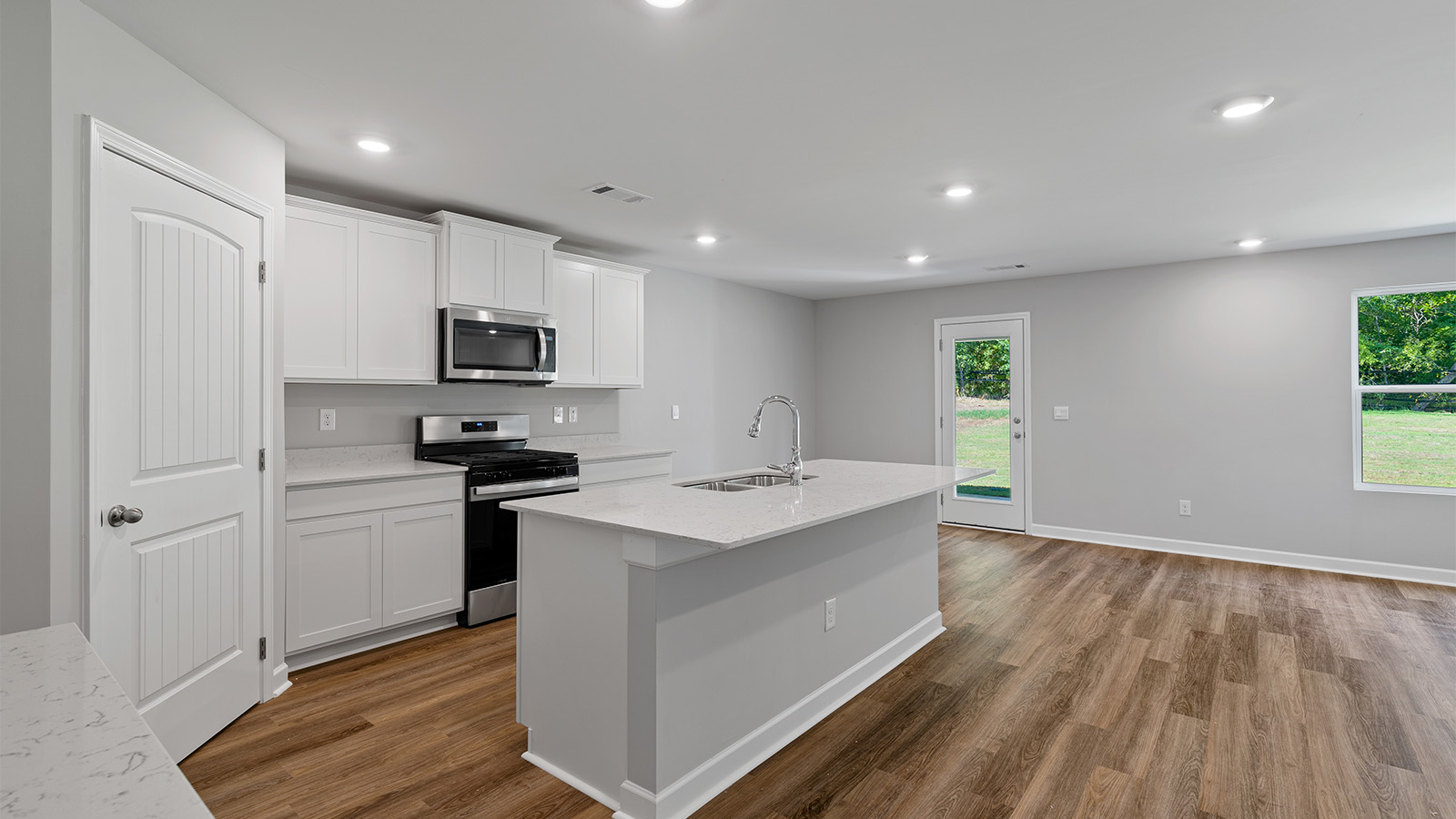 luxury vinyl plank flooring in kitchen with stainless steel appliances and Quartz countertops with soft close cabinets