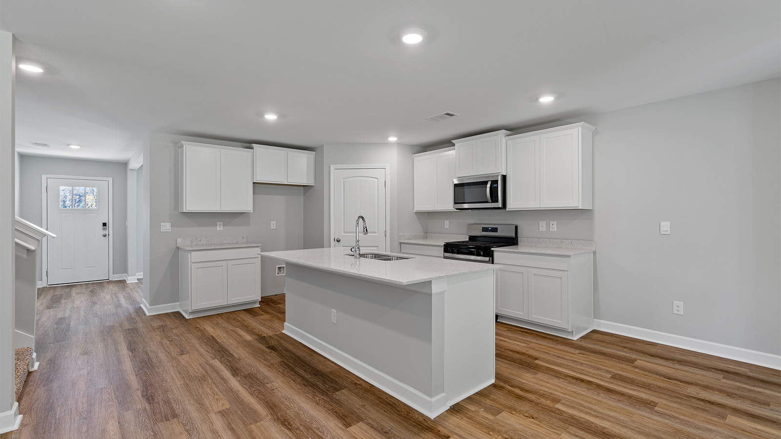 luxury vinyl plank flooring in kitchen with stainless steel appliances and Quartz countertops with soft close cabinets