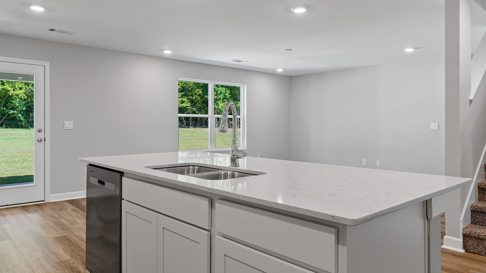 luxury vinyl plank flooring in kitchen with stainless steel appliances and Quartz countertops with soft close cabinets