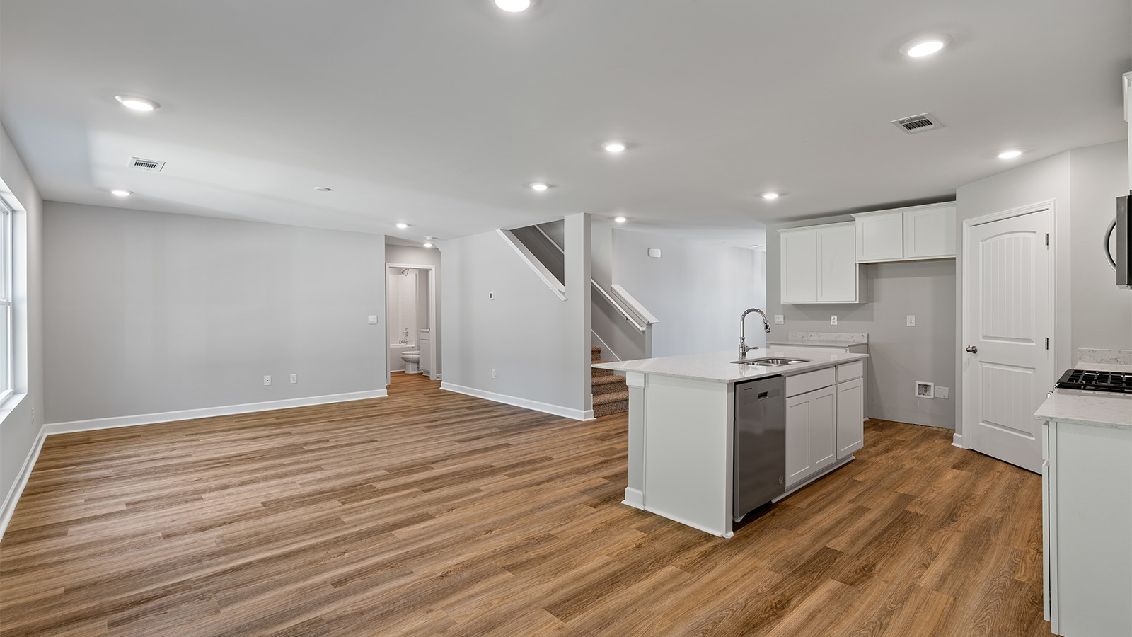 luxury vinyl plank flooring in kitchen with stainless steel appliances and Quartz countertops with soft close cabinets