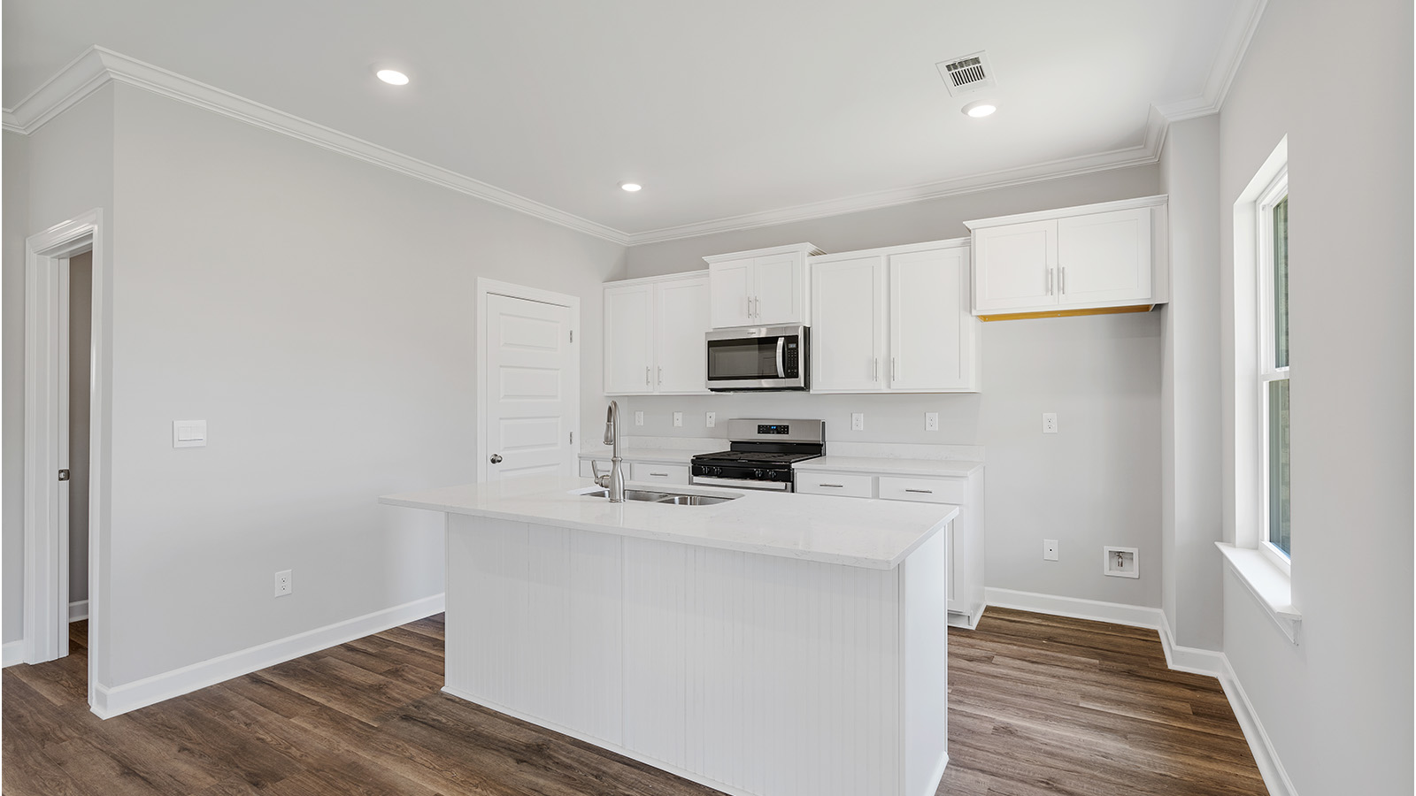 luxury vinyl plank flooring in kitchen with stainless steel appliances and Quartz countertops with soft close cabinets