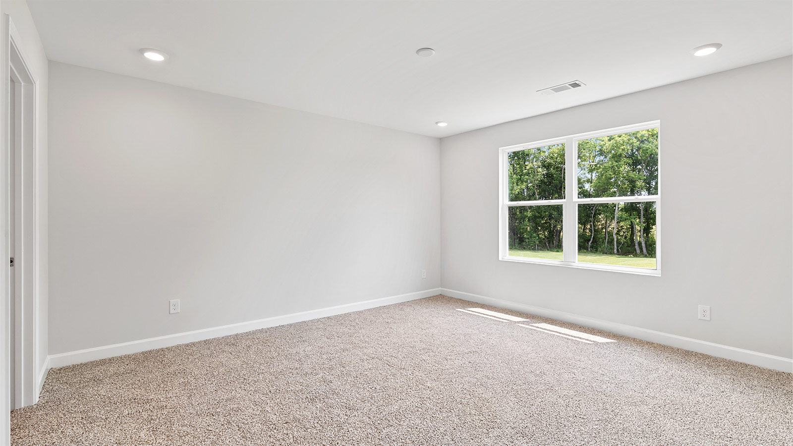 Spacious guest bedroom with soft carpet and full closet