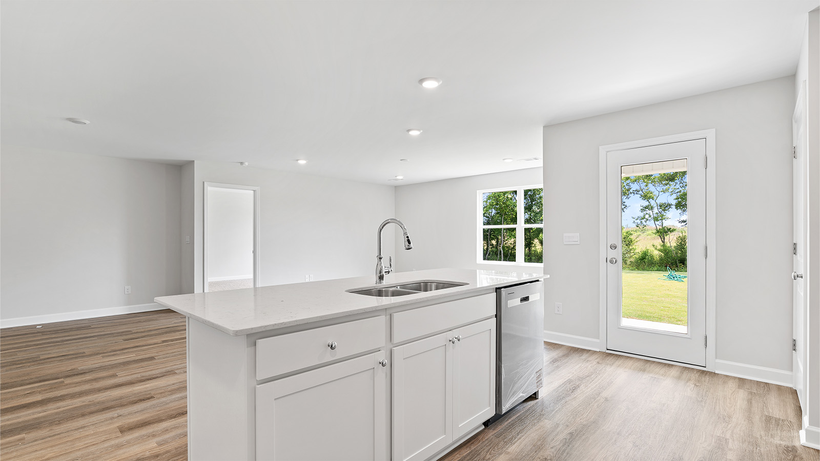 luxury vinyl plank flooring in kitchen with stainless steel appliances and Quartz countertops with soft close cabinets