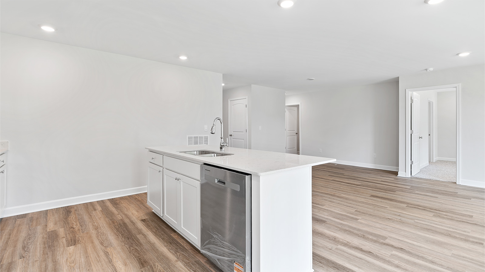 luxury vinyl plank flooring in kitchen with stainless steel appliances and Quartz countertops with soft close cabinets