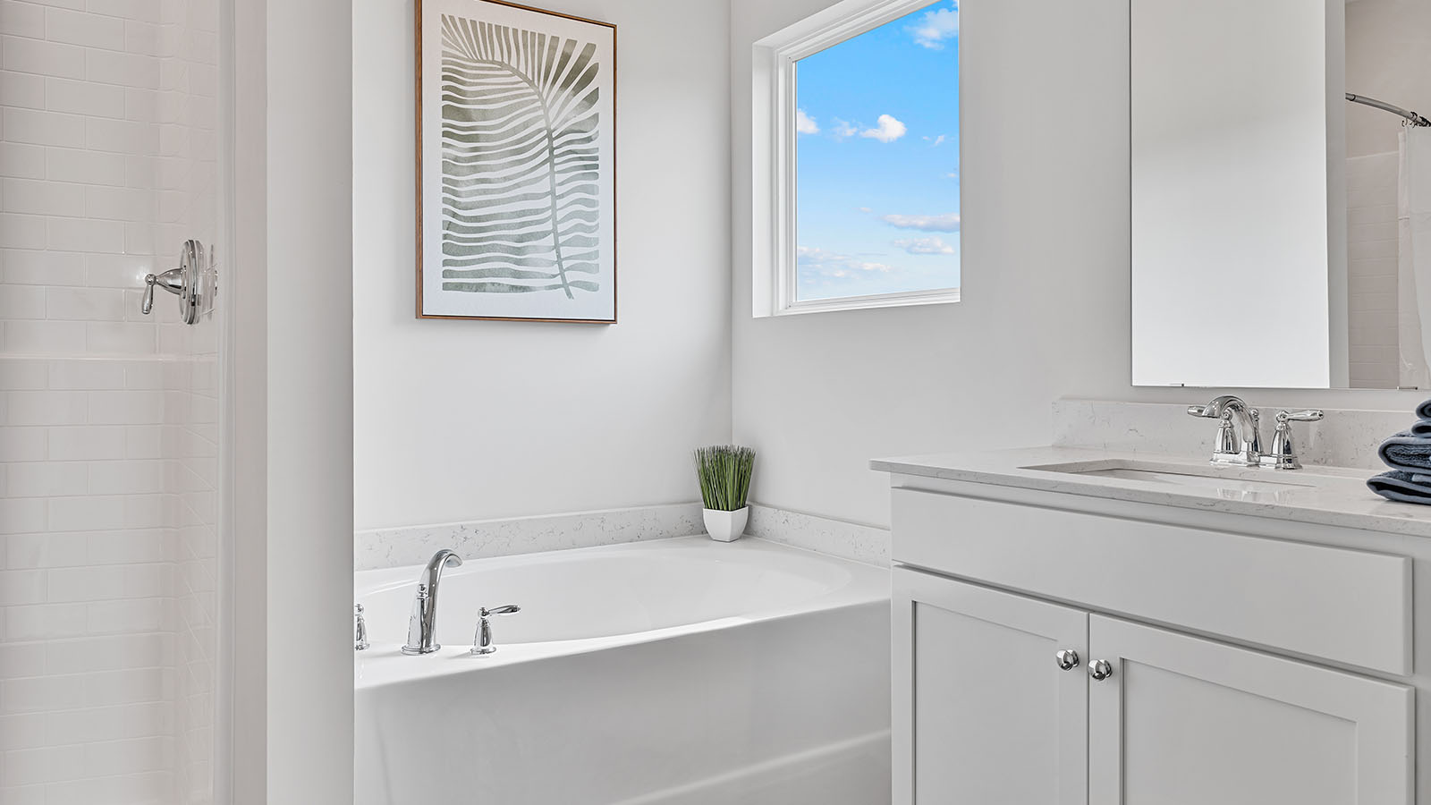 Spacious primary bath with double quartz vanities, separate shower, and garden tub.