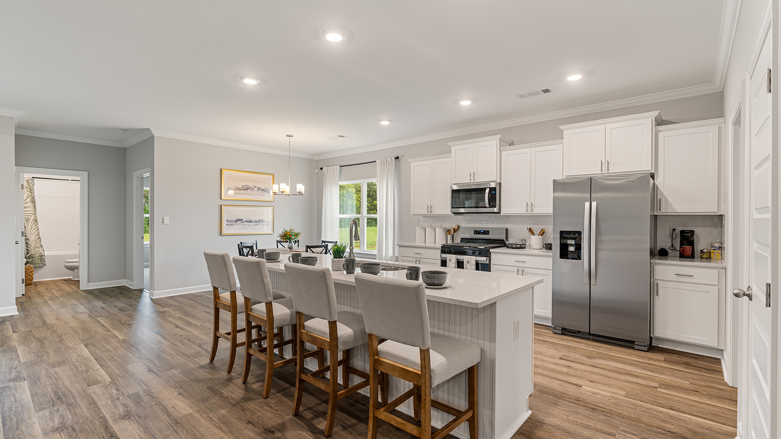 luxury vinyl plank flooring in kitchen with stainless steel appliances and Quartz countertops with soft close cabinets