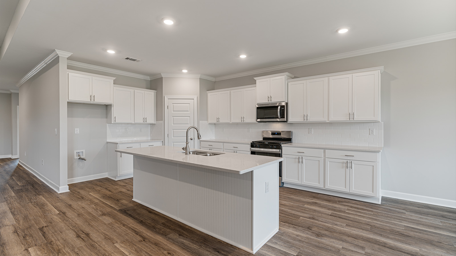 luxury vinyl plank flooring in kitchen with stainless steel appliances and Quartz countertops with soft close cabinets