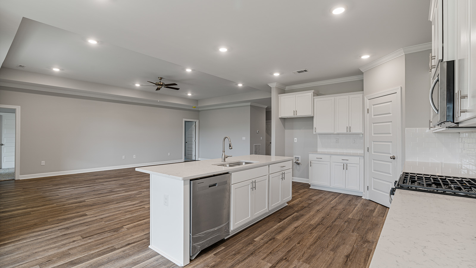 luxury vinyl plank flooring in kitchen with stainless steel appliances and Quartz countertops with soft close cabinets