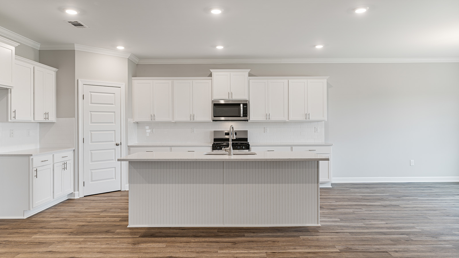 luxury vinyl plank flooring in kitchen with stainless steel appliances and Quartz countertops with soft close cabinets
