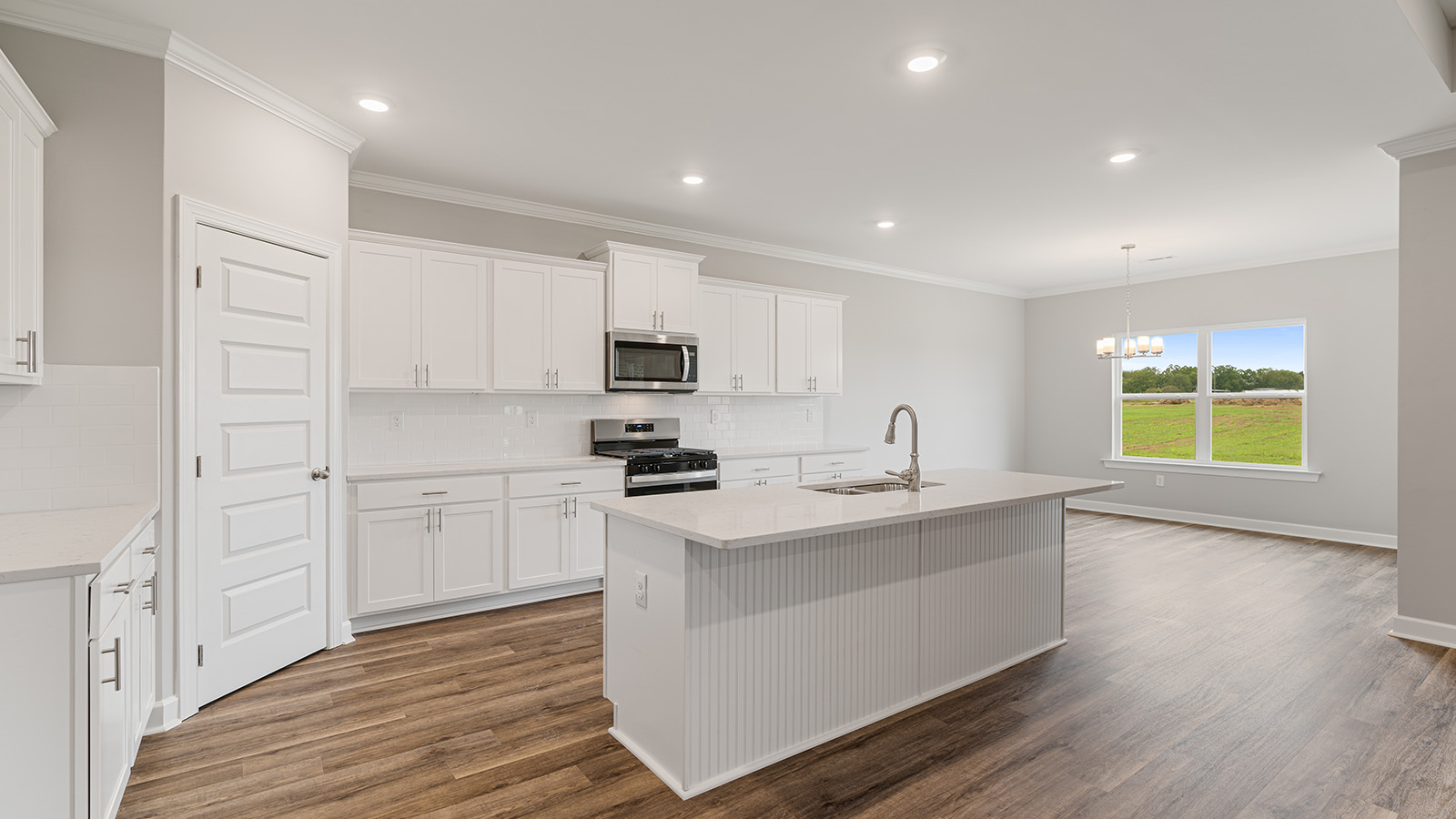 luxury vinyl plank flooring in kitchen with stainless steel appliances and Quartz countertops with soft close cabinets