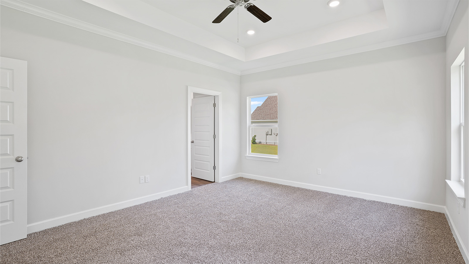 Primary bedroom featuring plush carpet and abundant natural light