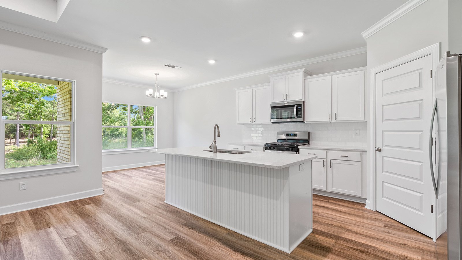 luxury vinyl plank flooring in kitchen with stainless steel appliances and Quartz countertops with soft close cabinets