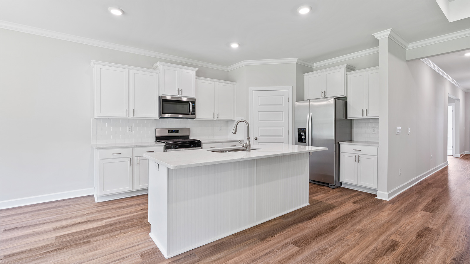 luxury vinyl plank flooring in kitchen with stainless steel appliances and Quartz countertops with soft close cabinets
