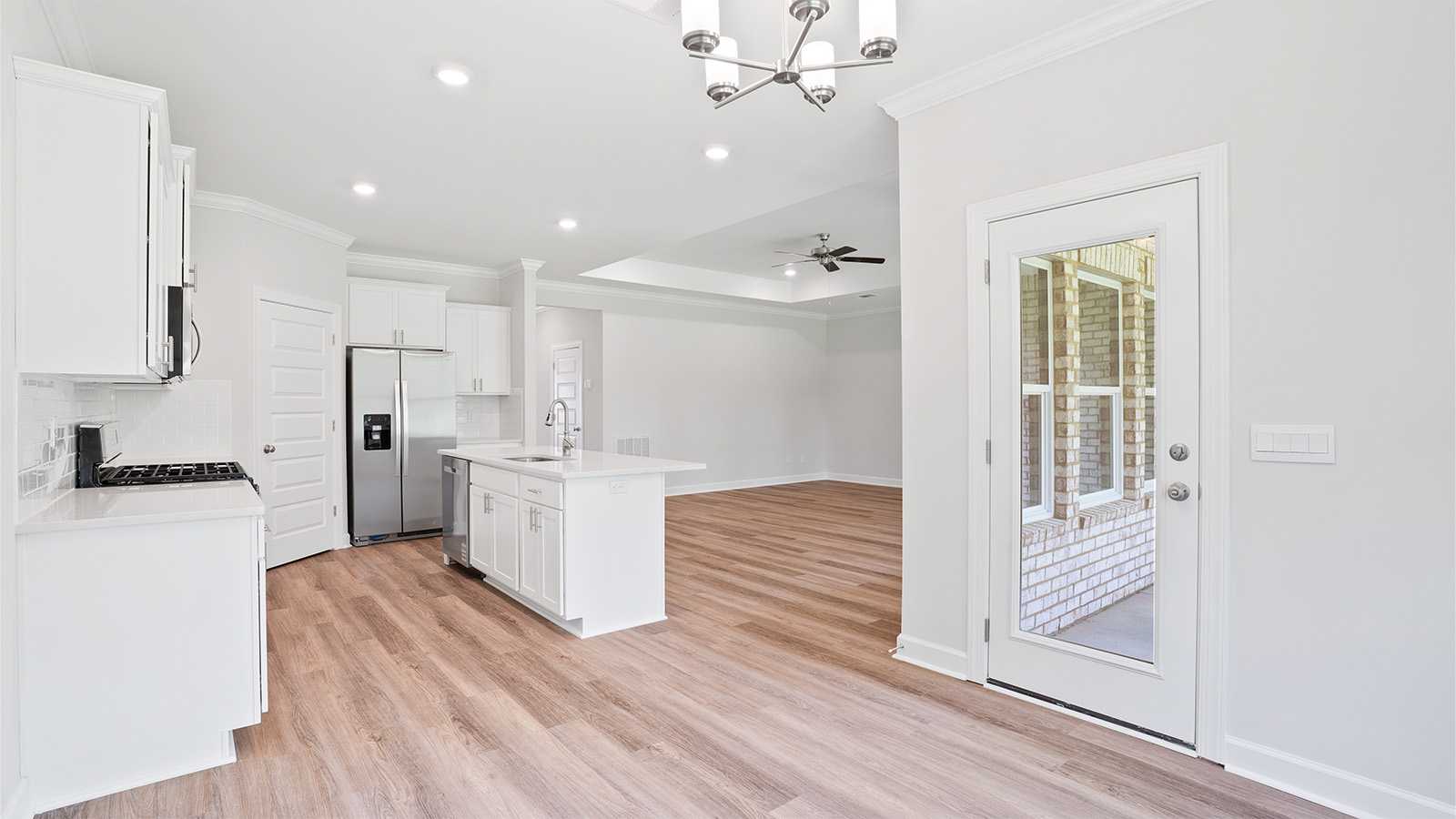 luxury vinyl plank flooring in kitchen with stainless steel appliances and Quartz countertops with soft close cabinets