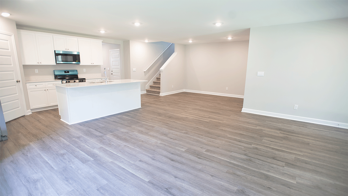 luxury vinyl plank flooring in kitchen with stainless steel appliances and Quartz countertops with soft close cabinets