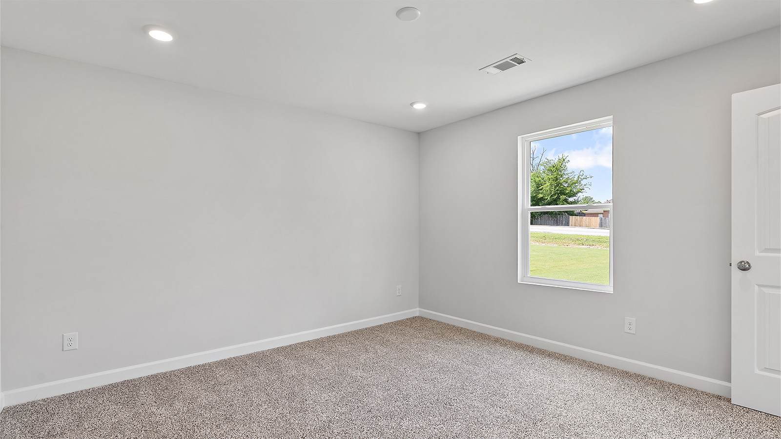 Primary bedroom featuring plush carpet and abundant natural light