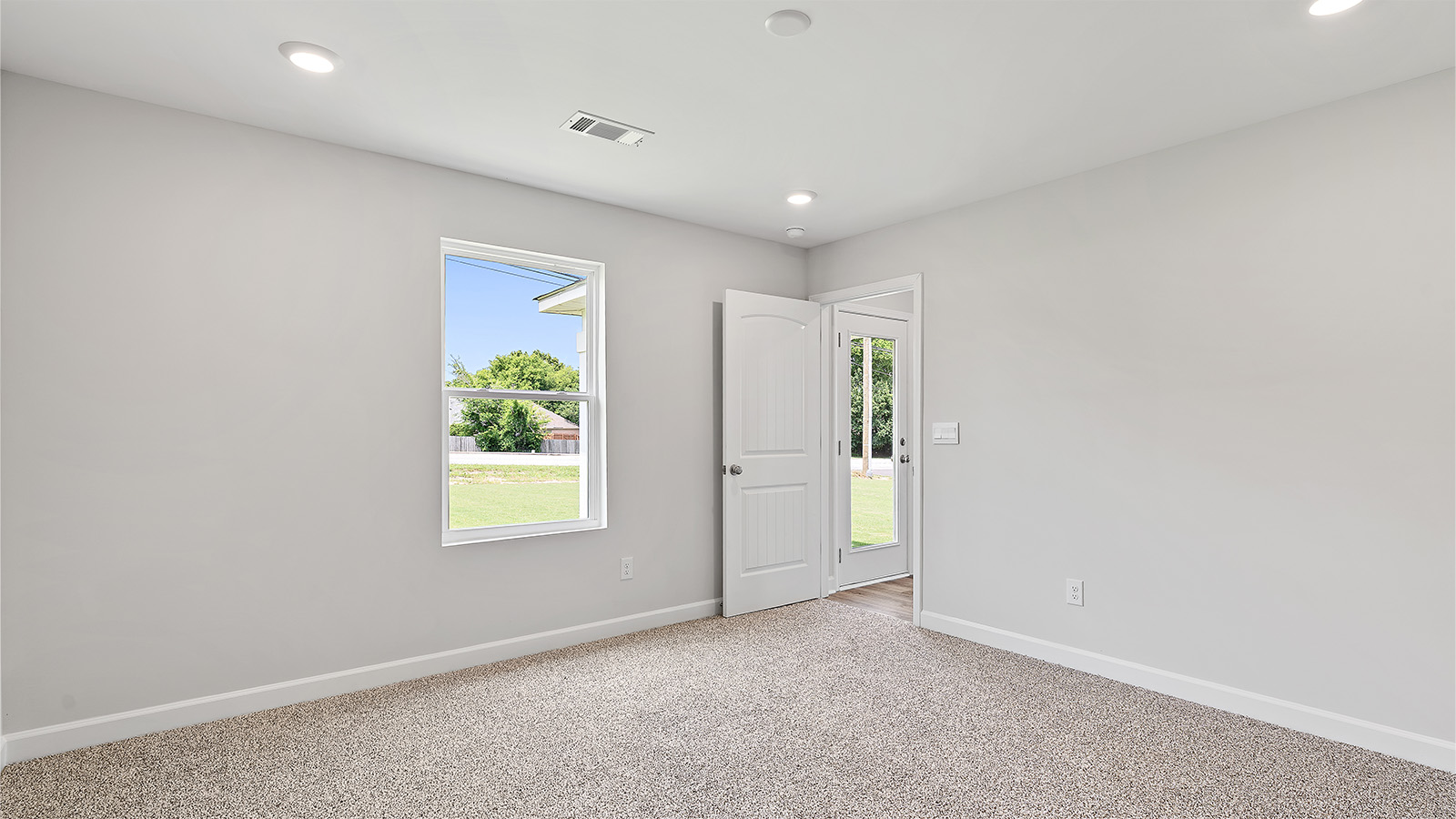 Primary bedroom featuring plush carpet and abundant natural light