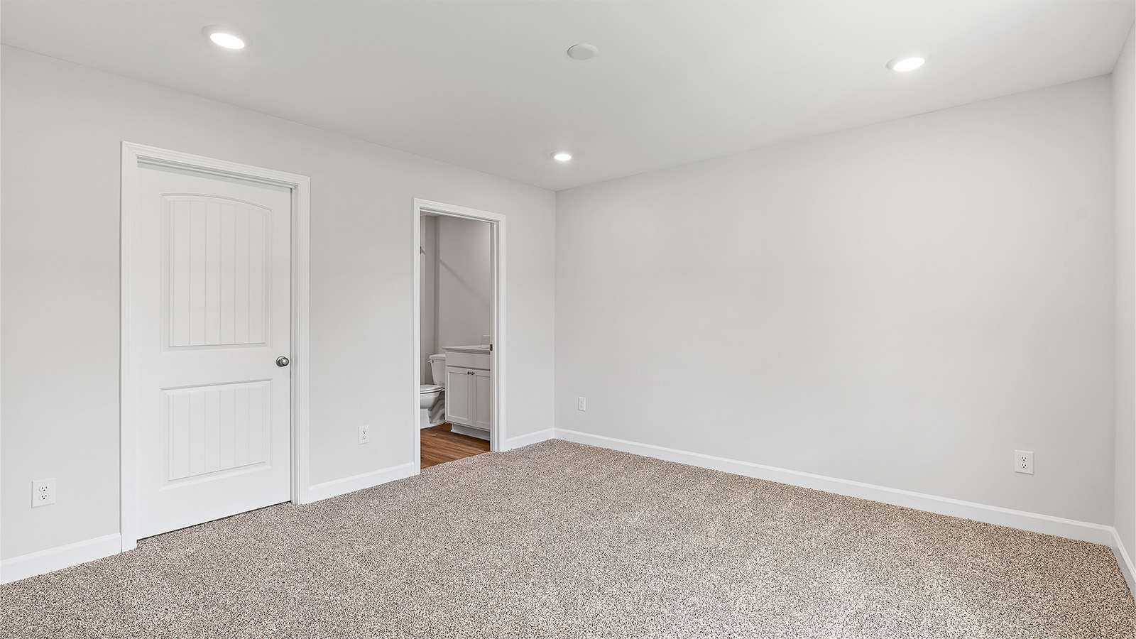 Spacious secondary bedroom with soft carpet and full closet